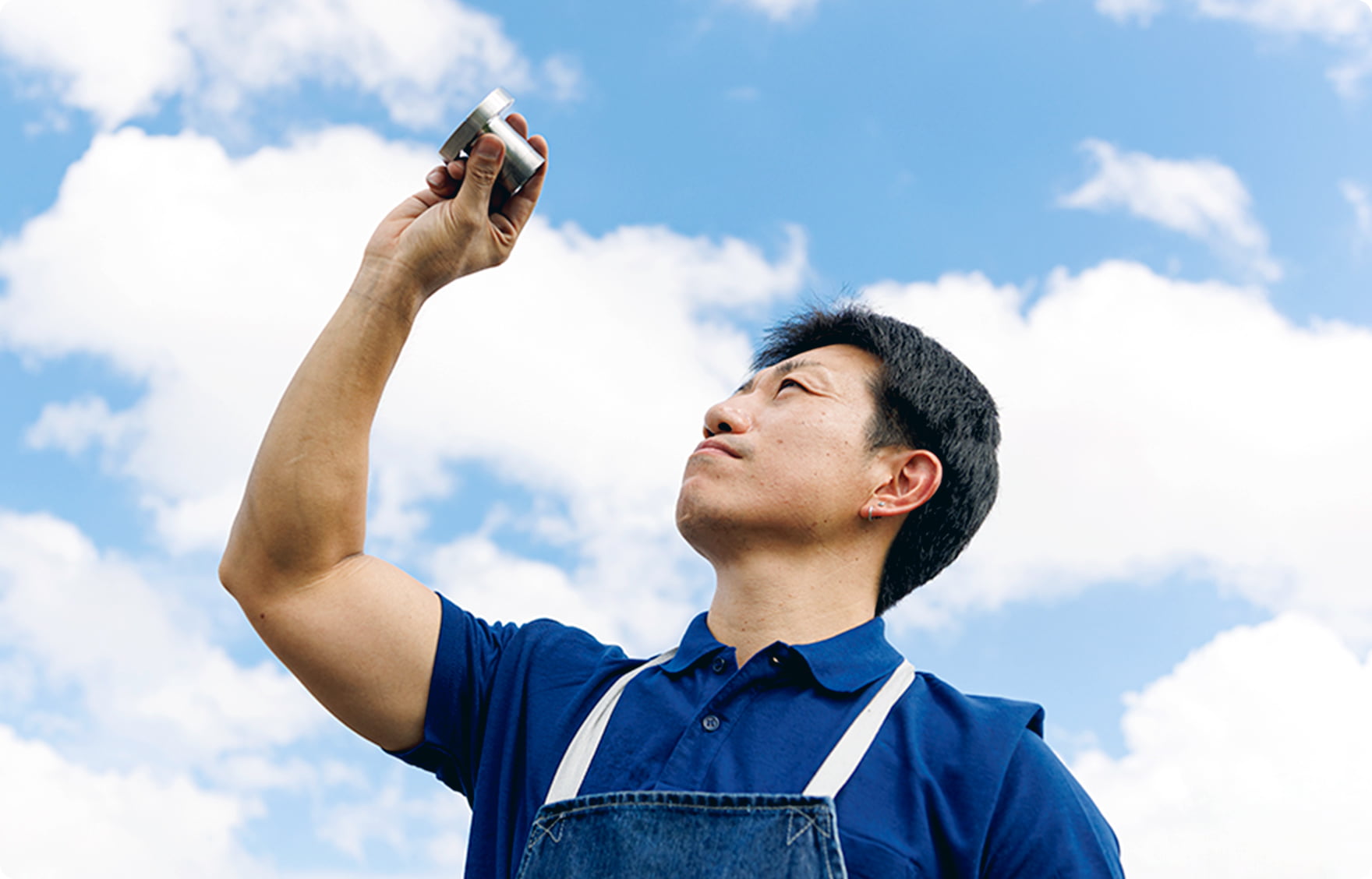 製品と空を見上げる職人